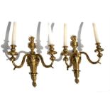 A pair of gilt bronze twin-arm wall sconces, 40cms (15.75ins) high (2).