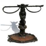 A Victorian cast iron stick stand in the form of a begging dog holding a riding crop in his mouth,