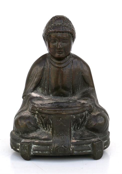 A Chinese bronze incense burner in the form of a seated Buddha, 10cms (4ins) high.