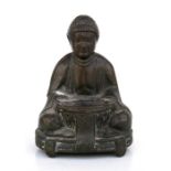A Chinese bronze incense burner in the form of a seated Buddha, 10cms (4ins) high.