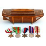 A WW2 medal group of five including the Italy and Africa Stars and a scratch built wooden model of a