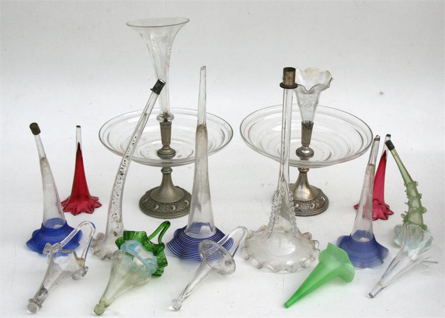 A quantity of eperne flutes including cranberry glass and Vaseline glass.