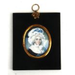 A portrait miniature of a lady wearing a bonnet with a blue ribbon, 6 by 7.5cms (2.25 by 3ins).