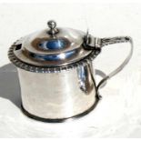 A George IV silver mustard pot with shell thumb piece and leaf capped handle, London 1823, 7.5cms (