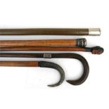 A silver mounted walking cane; a horn handled walking stick; and other walking sticks (5).