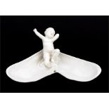 A Royal Worcester porcelain figure of a young child sat on a large open mussel shell, 21cms (8.