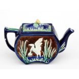 A majolica teapot decorated in relief with a wading bird, 15cms (6ins) high.