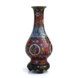 A 19th century Chinese cloisonne vase on integral stand, decorated bats and foliate scrolls on a red