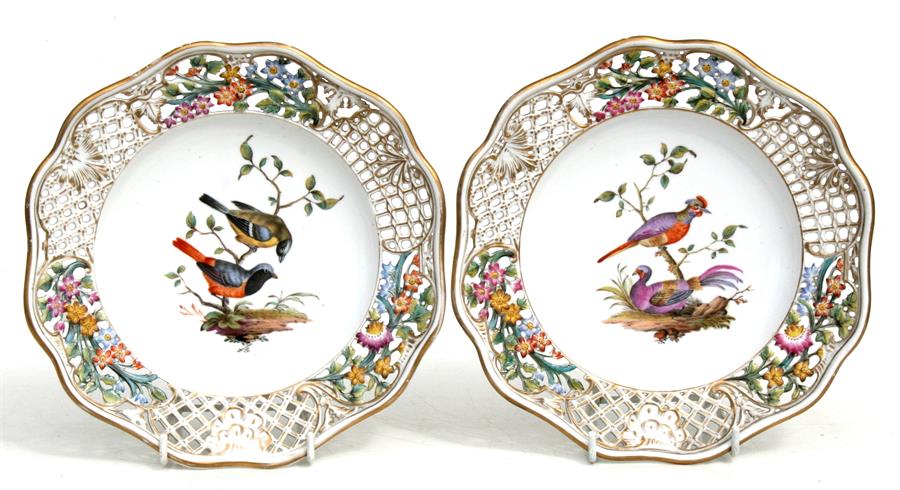 A pair of Augustus Rex porcelain plates decorated with birds within a pierced and foliate border,