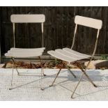 A pair of folding metal garden chairs.