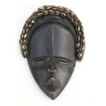 African / Tribal Art - a carved wooden mask with shell decoration, 30cms (11.75ins) high.