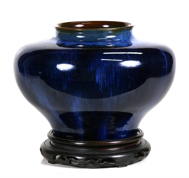 A Denby blue glazed vase of compressed globular form, on an associated pierced hardwood stand, 22cms