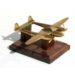 A brass model of the American WW2 Lockheed P38 Lightning sitting on a wooden base. Wingspan 20cms (