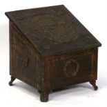A brass log box, the top decorated with an heraldic crest, 46cms (18ins) wide.