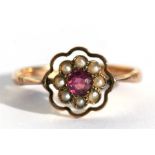 A 9ct gold dress ring set with a central pale garnet surrounded by seed pearls, approx UK size 'M'.