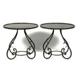 A pair of oval wrought iron occasional tables, 61cms (24ins) wide.