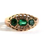 An Edwardian 9ct gold ring set with three green stones surrounded by diamonds, Chester 1909,
