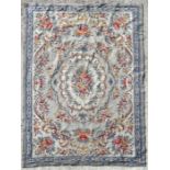 An Aubusson style needlepoint rug decorated with flowers on a blue ground, 117 by 178cms (46 by