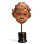 A mid 20th century terracotta sculpture depicting a young boy, 20cms (8ins) high.