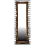 A rectangular carved gilt wood framed mirror, 48 by 160cms (19 by 63ins).
