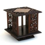 A carved hardwood tabletop revolving bookcase, pierced and carved with foliage & berries, 30.5cms (