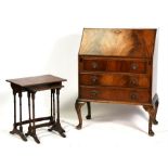 A figured mahogany bureau with three long drawers, on cabriole legs, 75cms (29.5ins) wide;