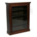 A late Victorian stained walnut pier cabinet, having single glazed panel door enclosing shelves on a