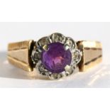 A 9ct gold dress ring set with a central amethyst surrounded by diamonds, approx UK size 'O'.