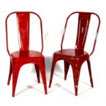 A pair of retro style red painted metal chairs.