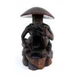 A carved hardwood figure depicting a kneeling man and his dog, 39cms (15.25ins) high