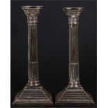 A pair of silver Corinthian column candlesticks on square stepped bases, 30.5 (12ins) high. (a/f)