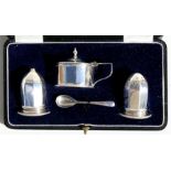An Art Deco cased silver condiment set comprising salt, pepper & mustard pots, Birmingham 1925.