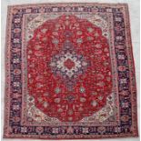 A handmade Persian Heriz carpet with geometric design on a red ground, 390 by 300cms (153.5 by
