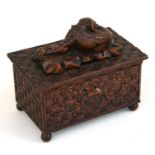 A carved Black Forest style box, the top surmounted with a dog, 22cms, 8.75ins) wide. Condition