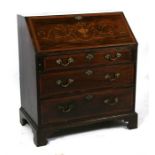 A 19th century mahogany bureau, the inlaid fall flap enclosing a sectioned interior above three long