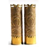 A matching pair of WWII brass shell case vases elaborately decorated with embossed lucky