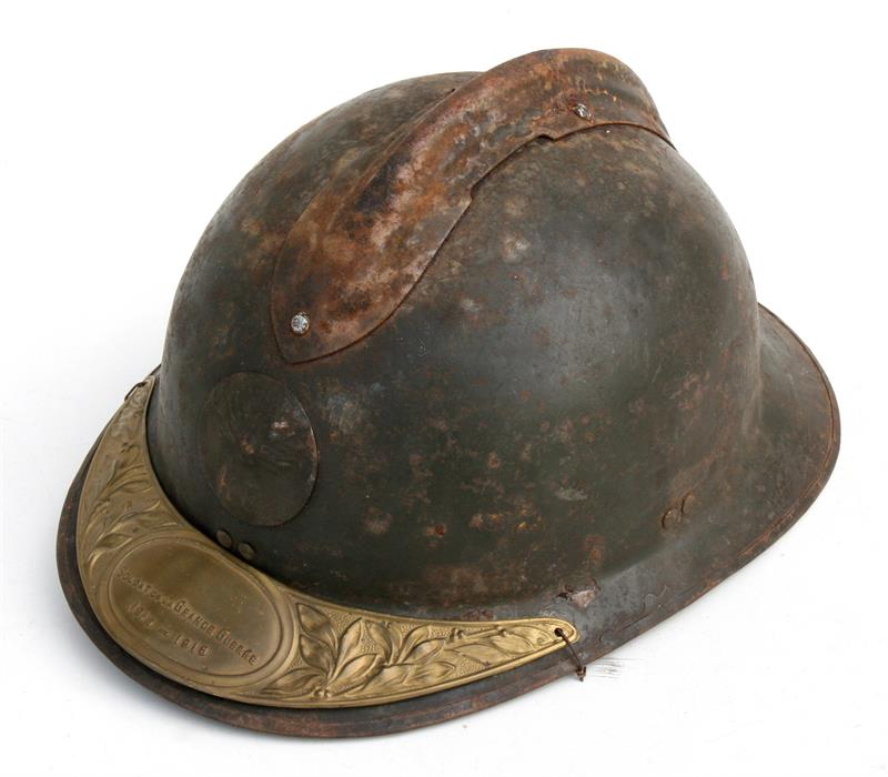 A French Adrian helmet with Soldat De La Grande Guerre 1914-1918 brass plaque attached to the visor