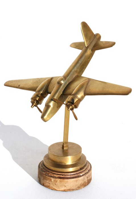 A brass model of the WW2 light bomber the Bristol Blenheim standing on its brass and wood base.