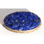 A Chinese oval Lapis Lazuli gilt metal mounted brooch, 4 by 2.5cms (1.5 by 1ins).Condition