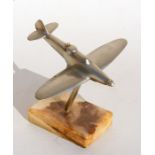 A chrome plated model of the WW2 British fighter aircraft the Blackburn Roc standing on a marble