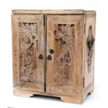 A Chinese carved camphor wood table top cabinet, the pair of figural carved doors enclosing two