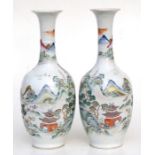 A pair of Chinese famille rose vases decorated with a mountainous river scene with gilt