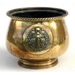 A brass pot, the decoration depicting the Glastonbury arms, 22cms (8.5ins) wide.