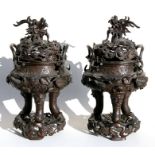 An impressive pair of Chinese bronze dragon censers on stands, the pierced covers in the form of