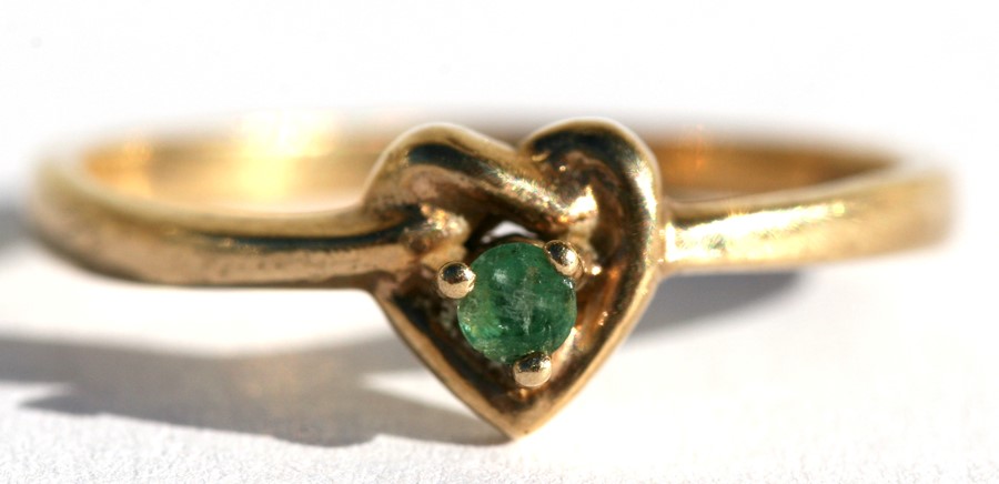 A 9ct gold dress ring set with a central emerald within a heart shaped knot, approx UK size 'N'.