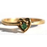 A 9ct gold dress ring set with a central emerald within a heart shaped knot, approx UK size 'N'.