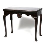 A 19th century mahogany card table on cabriole legs, with central shell motif decoration to the