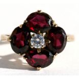 An Edwardian style 9ct gold dress ring set with four garnets and a central white stone, approx UK