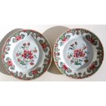 A pair of early 18th century famille rose plates decorated with peonies, 23cms (9ins) diameter.