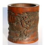 A Chinese bamboo brush pot, deeply carved with boats and figures on a shoreline and calligraphy,